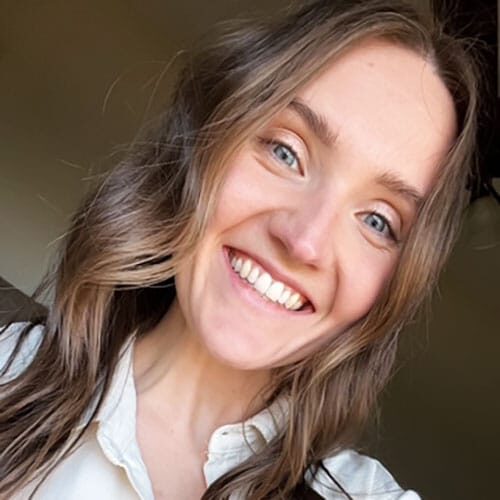 Smiling woman with long wavy hair and bright blue eyes.